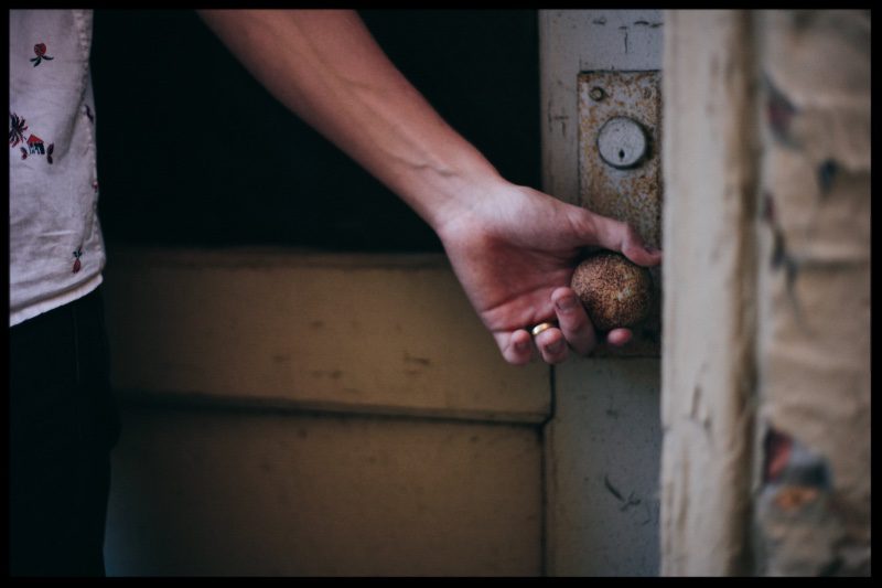 Man holding a rusted door knob